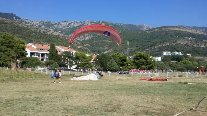 Paraglider canopy and landing field near the Budva coast after a tandem flight
