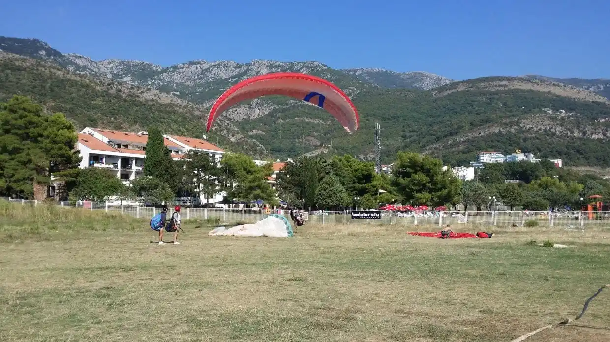 Paraglider canopy and landing field near the Budva coast after a tandem flight