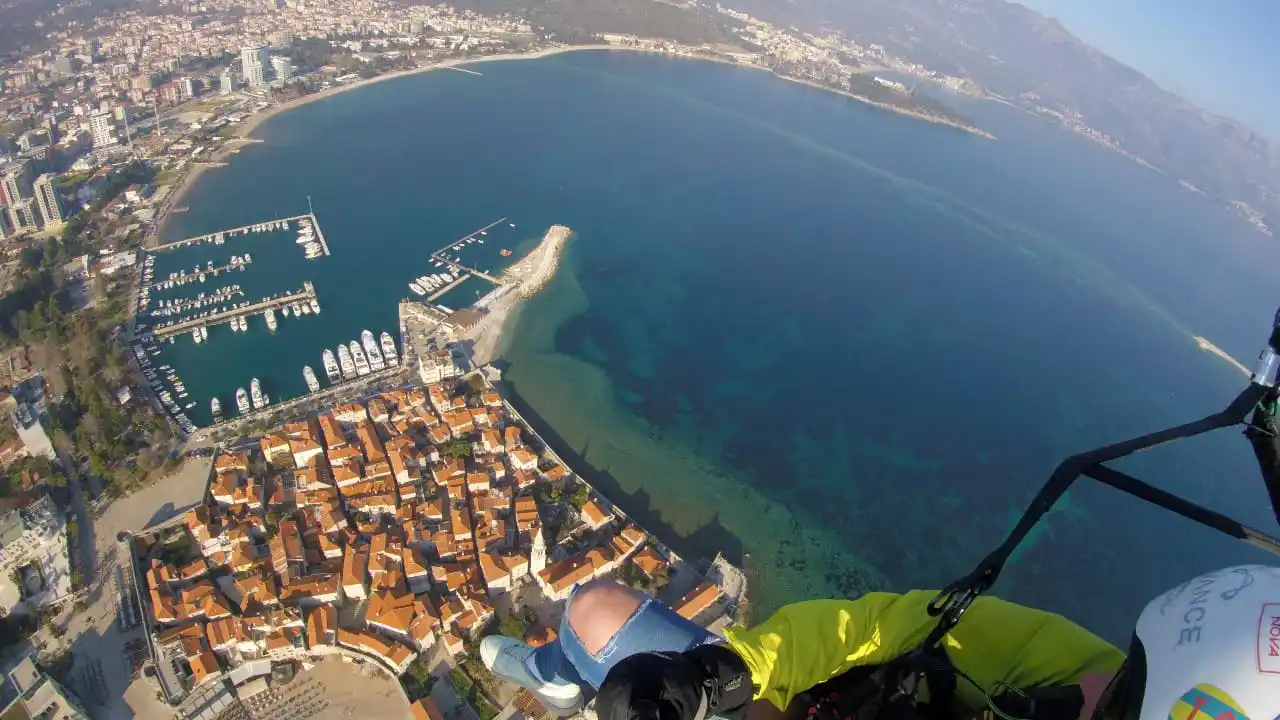 Tandem paragliding view over Budva Old Town, marina, and bay