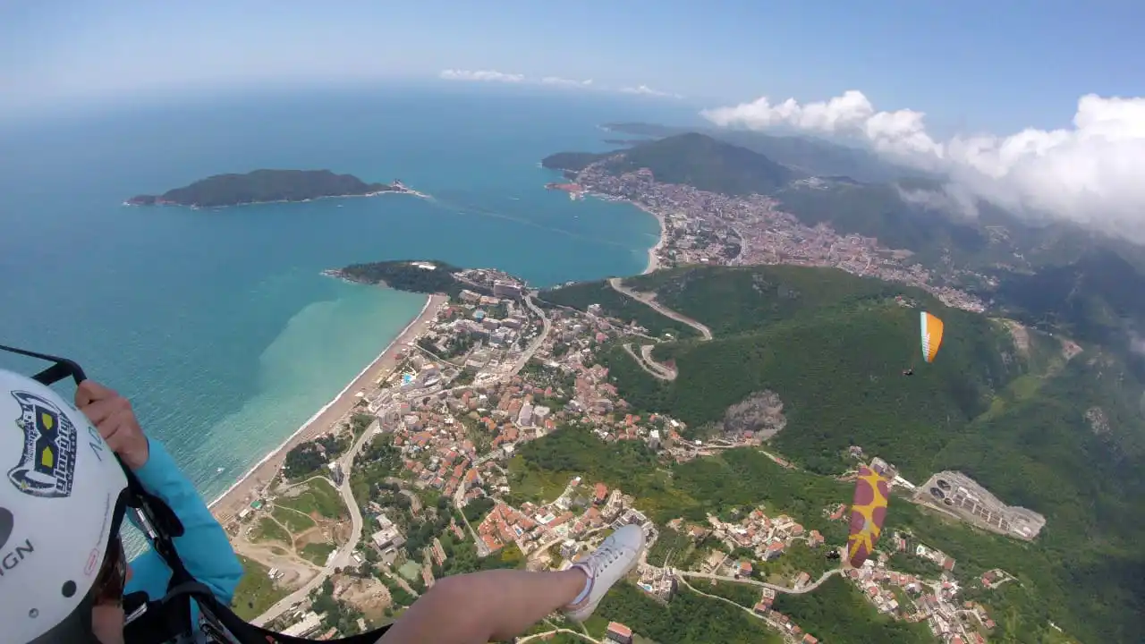 Take-off slope above Budva with paragliders and the coast in the distance